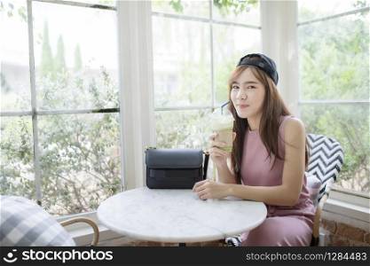 happiness smiling face of asian younger woman with cool bottle of green tea beverage