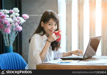 happiness smiling face of young asian woman drinking hot coffee as freelance working
