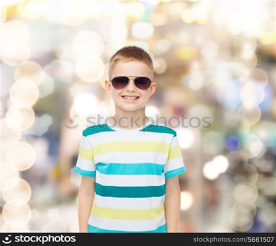 happiness, summer and people concept - smiling cute little boy in sunglasses over sparkling background