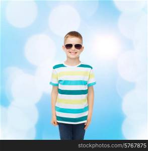 happiness, summer, childhood and people concept - smiling cute little boy in sunglasses over blue background