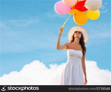 happiness, summer, holidays and people concept - smiling young woman wearing sunglasses with balloons over blue sky and cloud background