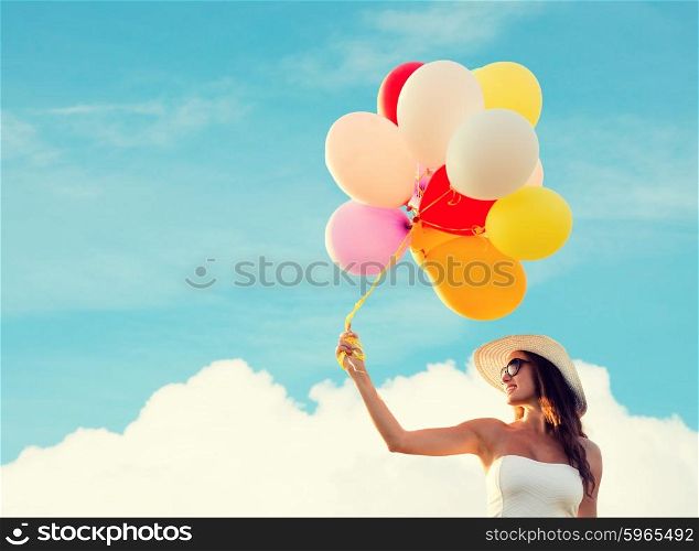 happiness, summer, holidays and people concept - smiling young woman wearing sunglasses with balloons over blue sky and cloud background