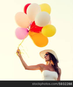 happiness, summer, holidays and people concept - smiling young woman wearing sunglasses with balloons outdoors