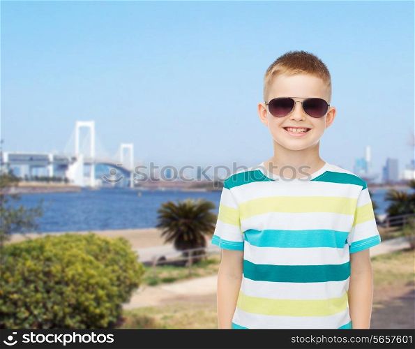 happiness, summer, travel, childhood and people concept - smiling cute little boy in sunglasses