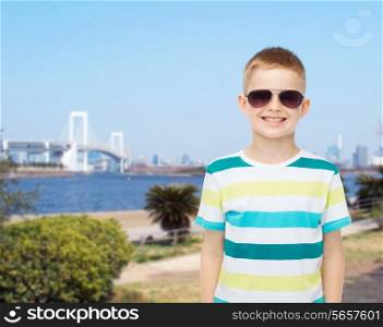 happiness, summer, travel, childhood and people concept - smiling cute little boy in sunglasses