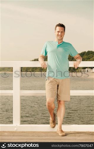 Happiness summer vacation and people concept. Fashion portrait of handsome man on pier sea landscape