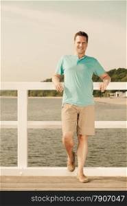 Happiness summer vacation and people concept. Fashion portrait of handsome man on pier sea landscape