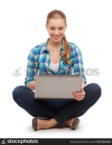 happiness, technology, internet and people concept - smiling young woman sitting on floor with laptop computer