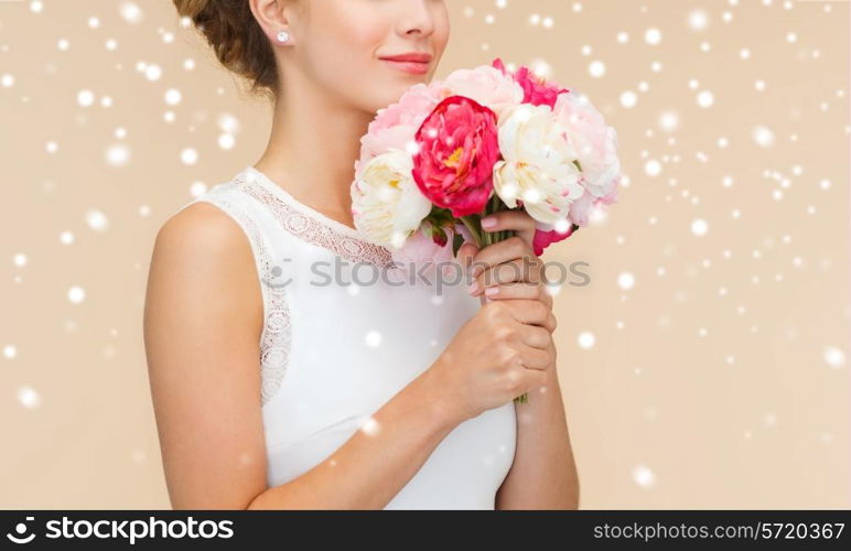 happiness, wedding, holidays and celebration concept - close up of smiling bride or bridesmaid in white dress with bouquet of flowers over beige background and snow