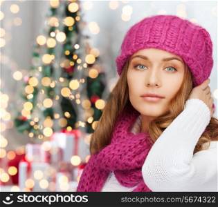 happiness, winter holidays and people concept - smiling young woman in pink hat and scarf over christmas tree with presents background