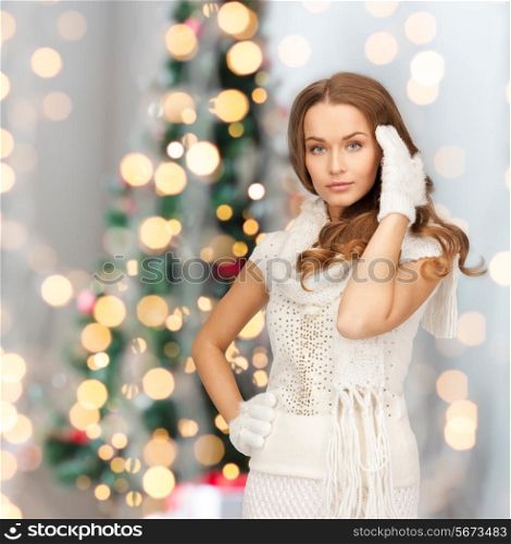 happiness, winter holidays and people concept - smiling young woman in white warm clothes over christmas tree lights background