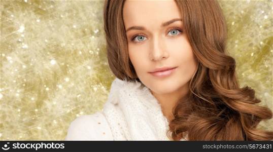 happiness, winter holidays, christmas and people concept - close up of smiling young woman in white warm clothes over yellow lights background