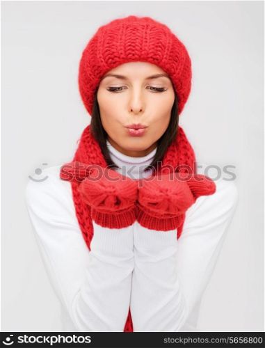 happiness, winter holidays, christmas and people concept - smiling young woman in red hat, scarf and mittens over gray background