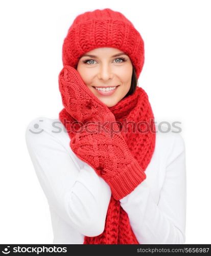 happiness, winter holidays, christmas and people concept - smiling young woman in red hat, scarf and mittens over white background