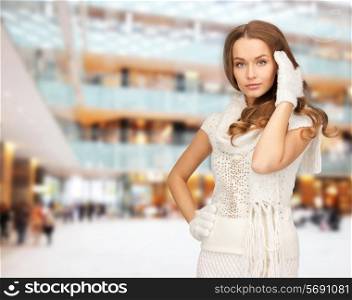 happiness, winter holidays, christmas and people concept - smiling young woman in white warm clothes over shopping center background