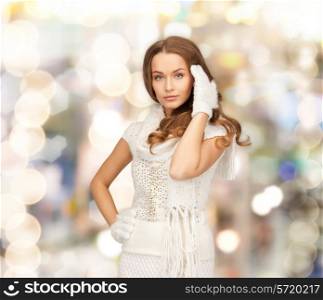happiness, winter holidays, christmas and people concept - smiling young woman in white warm clothes over lights background
