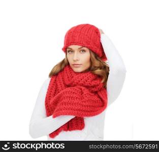 happiness, winter holidays, christmas and people concept - young woman in red hat and scarf over white background
