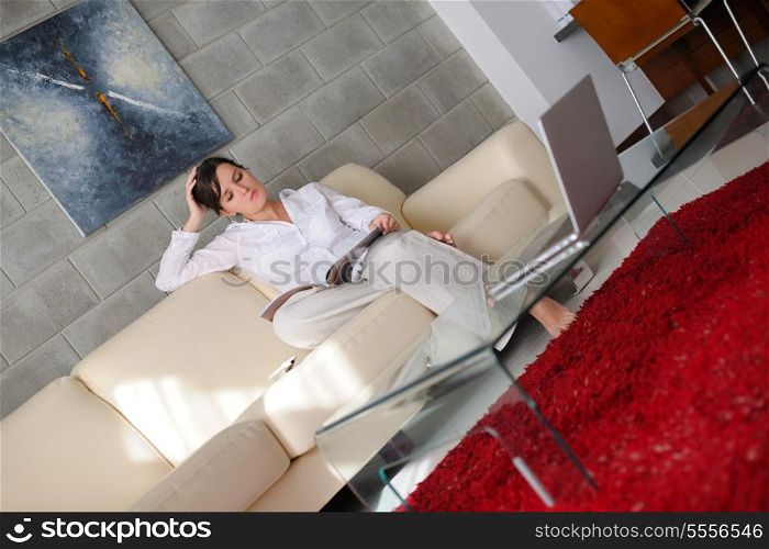 happpy young woman reading magazina at home in comfortabel sofa and bright living room