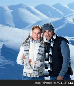 Happy active couple spending winter holidays in the mountains covered with snow, young family with pleasure travel together