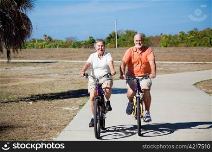 Happy active senior couple riding their bicycles.