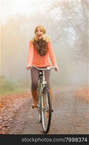 Happy active woman riding bike in autumn park.. Happy active woman riding bike bicycle in fall autumn park. Glad young girl relaxing. Healthy lifestyle..