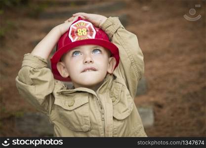 Happy Adorable Child Boy with Fireman Hat Playing Outside.