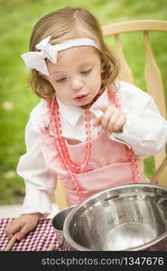 Happy Adorable Little Girl Playing Chef Cooking in Her Pink Outfit.