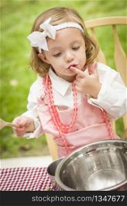 Happy Adorable Little Girl Playing Chef Cooking in Her Pink Outfit.
