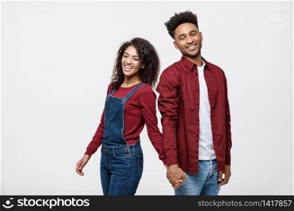 happy african american couple holding hands and looking back isolated on white.. happy african american couple holding hands and looking back isolated on white