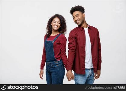happy african american couple holding hands and looking back isolated on white.. happy african american couple holding hands and looking back isolated on white