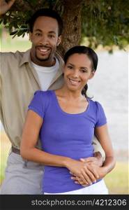 Happy African American Couple Holding Hands Under A Tree