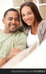 Happy African American Couple Sitting At Home