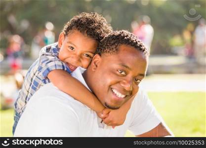 Happy African American Father and Mixed Race Son Playing At The Park.