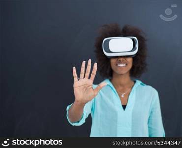 Happy african american girl getting experience using VR headset glasses of virtual reality, isolated on gray background
