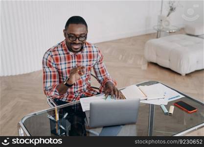 Happy african american guy has online conversation on computer. Businessman talking to client. Teacher is speaking to student. Remote study, distance learning, homework checking. Online tutor at work.. Happy african american guy has online conversation. Distance learning, homework checking.
