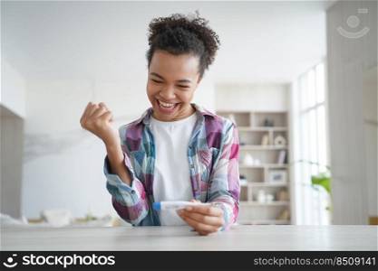 Happy african american teenage girl gets negative pregnancy test result. Satisfied young woman is excited and surprised. Pregnancy checking home test. Baby planning and contraception concept.. Happy african american teenage girl gets negative pregnancy test result. Contraception concept.