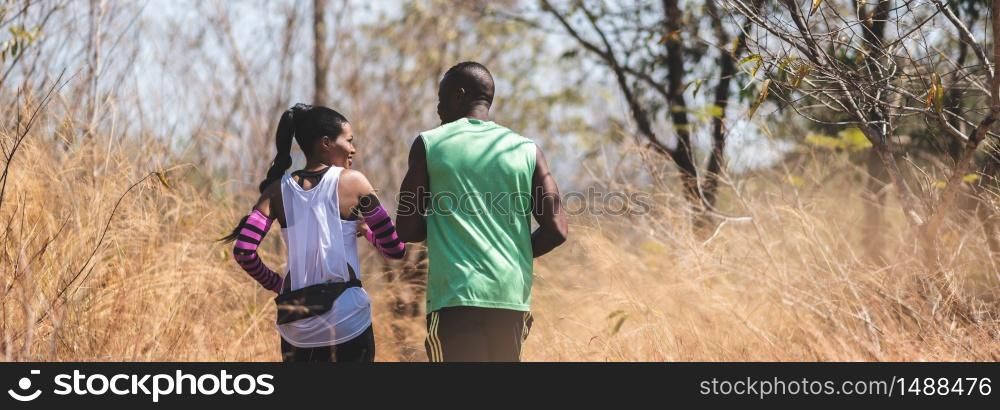 Happy African couple jogging in a autumn nature. Banner, Panoramic view. Healthy lifestyle and sport concepts