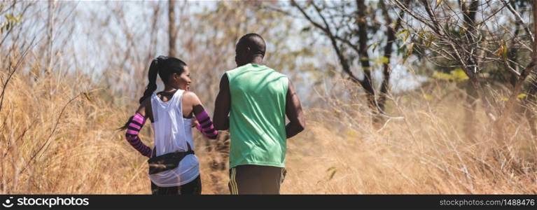 Happy African couple jogging in a autumn nature. Banner, Panoramic view. Healthy lifestyle and sport concepts