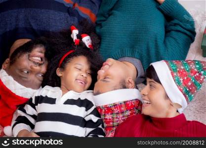 Happy African family lying smiling on Christmas day together while gift box on floor, top view, relationship and bonding of family, celebration and holiday, new year and xmas, fun and cozy.
