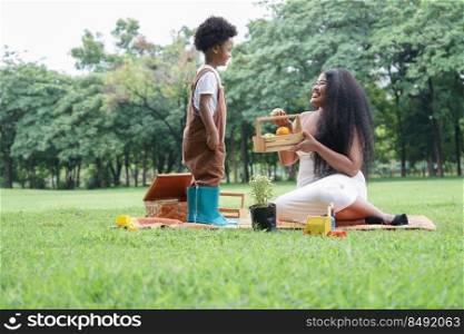 Happy African family Mother and son picnic together at garden green park on weekend	