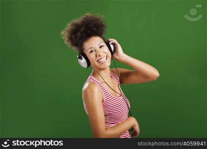 Happy African woman listen music, over a green background