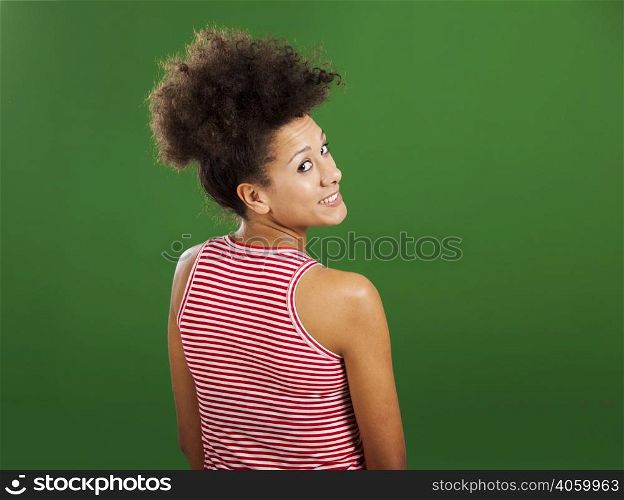 Happy African woman over a green background looking back