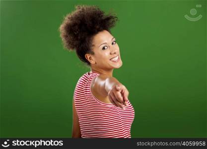 Happy African woman pointing to something over a green background