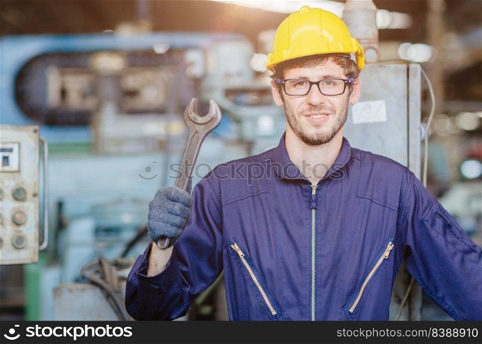 happy american teen worker handle wrench.engineer smiling for service maintenance fix machine in heavy industy with safty suit and helmet.