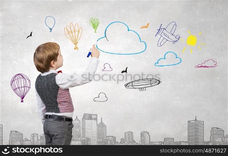 Happy and carefree childhood. Adorable kid boy drawing with marker sketches on wall