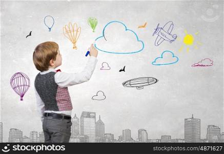 Happy and carefree childhood. Adorable kid boy drawing with marker sketches on wall