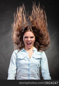 Happy and ecstatic woman having fun. Carefree young girl with long hair in motion. Wind.