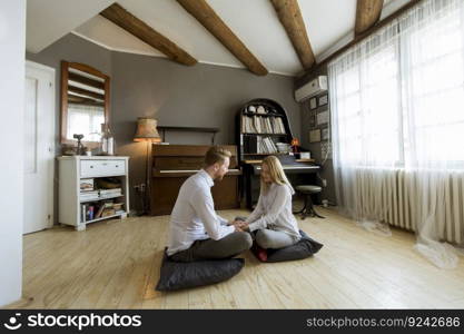 Happy and loving young couple sitting on the floor in the room