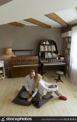 Happy and loving young couple sitting on the floor in the room