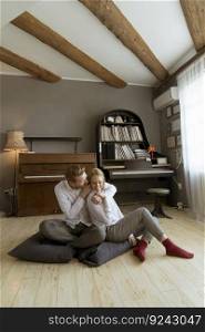 Happy and loving young couple sitting on the floor in the room